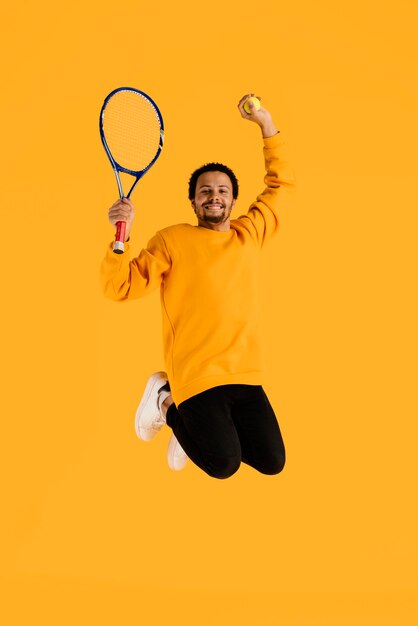 Portret jonge man springen met tennisracket