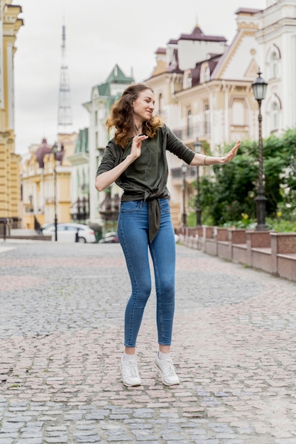 Portret jonge vrouw dansen op straat