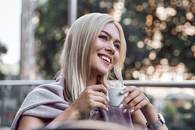 Portret jonge vrouw met glazen koffie drinken in café relax