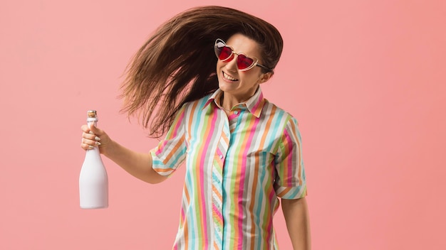 Portret jonge vrouw op feestje met champagne fles