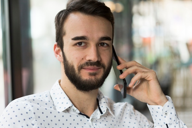 Portret knap mannetje dat over telefoon spreekt