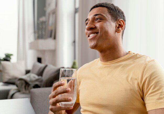 Portret man thuis glas water drinken