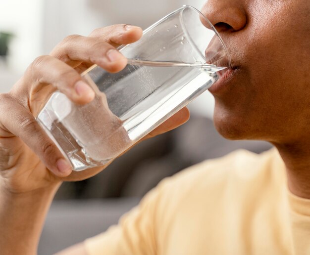 Portret man thuis glas water drinken