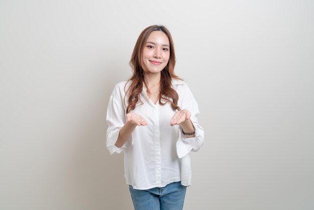 Portret mooie aziatische vrouw met hand presenteren of wijzen op witte achtergrond