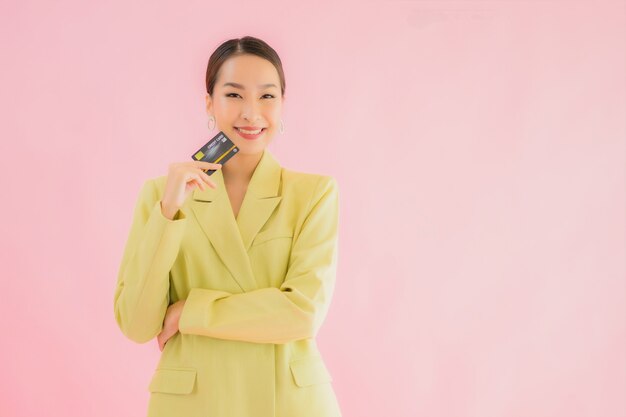 Portret mooie jonge Aziatische bedrijfsvrouw met creditcard op kleur
