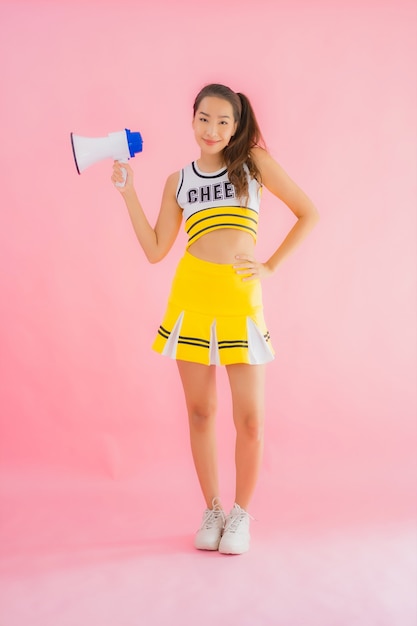 Portret mooie jonge aziatische vrouw cheerleader met megafoon