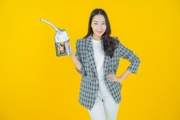 Portret mooie jonge aziatische vrouw feul benzinepomp op kleur achtergrond
