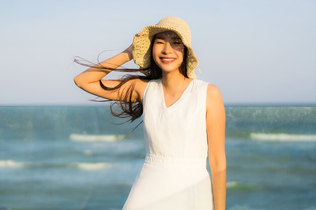 Portret mooie jonge Aziatische vrouw gelukkig en glimlach op het strand zee en de Oceaan