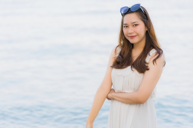 Portret mooie jonge Aziatische vrouw gelukkig en glimlach op het strand zee en de Oceaan