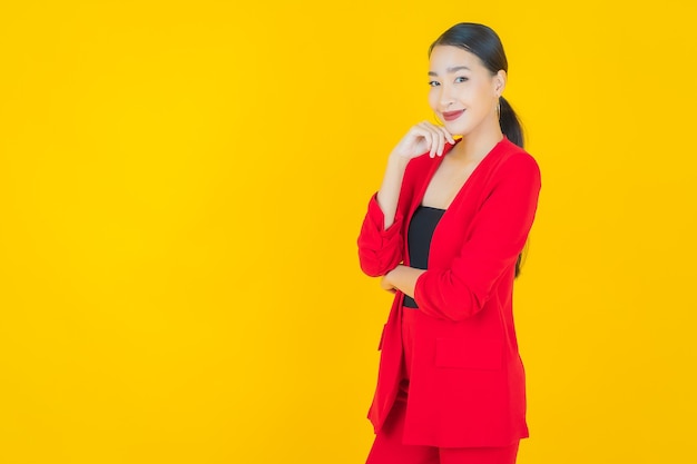 Portret mooie jonge Aziatische vrouw glimlach met actie op geel
