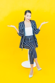 Portret mooie jonge aziatische vrouw glimlach met actie op kleur achtergrond