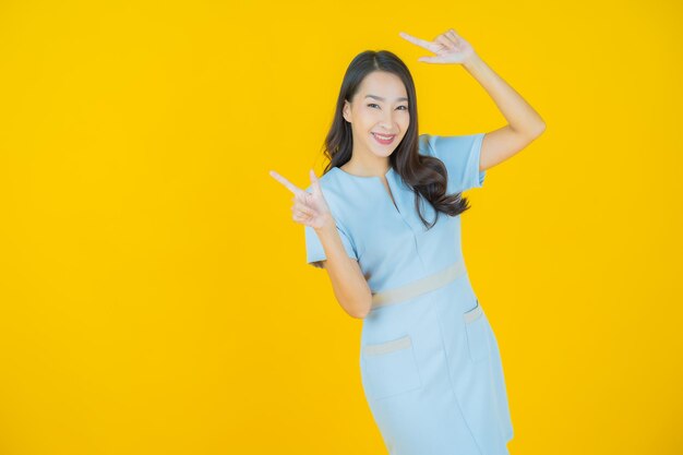 Portret mooie jonge Aziatische vrouw glimlach met actie op kleur achtergrond