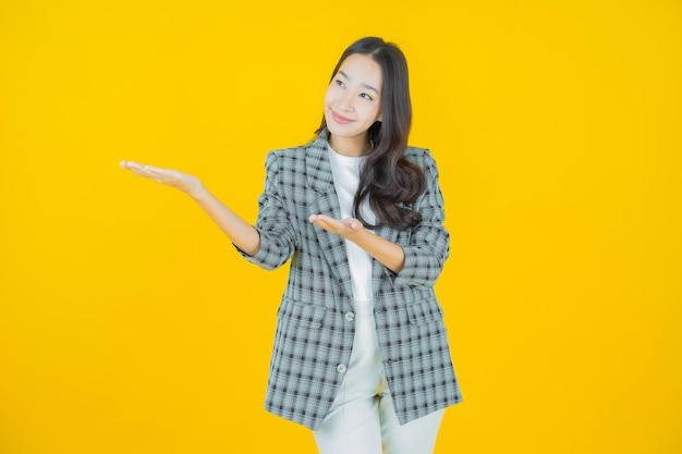 Portret mooie jonge Aziatische vrouw glimlach met actie op kleur achtergrond