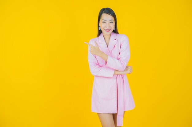 Portret mooie jonge Aziatische vrouw glimlach met actie op kleur achtergrond