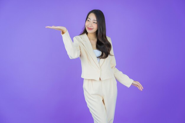 Portret mooie jonge Aziatische vrouw glimlach met actie op kleur achtergrond