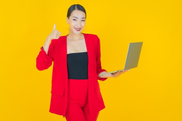 Portret mooie jonge Aziatische vrouw glimlach met computer laptop op geïsoleerde achtergrond