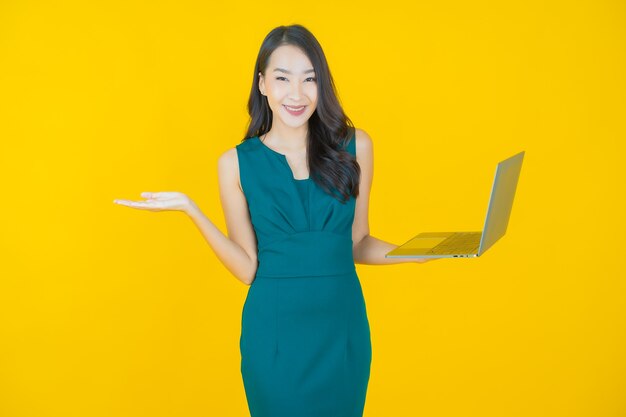 Portret mooie jonge Aziatische vrouw glimlach met computer laptop op geïsoleerde achtergrond