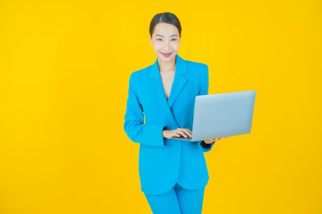 Portret mooie jonge Aziatische vrouw glimlach met computer laptop op geïsoleerde achtergrond