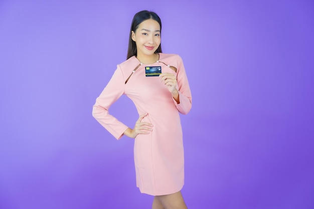 Portret mooie jonge aziatische vrouw glimlach met creditcard op kleur achtergrond
