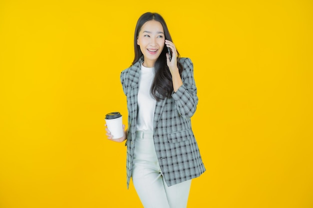 Portret mooie jonge Aziatische vrouw glimlach met slimme mobiele telefoon op kleur achtergrond