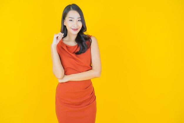 Portret mooie jonge Aziatische vrouw glimlach op geel