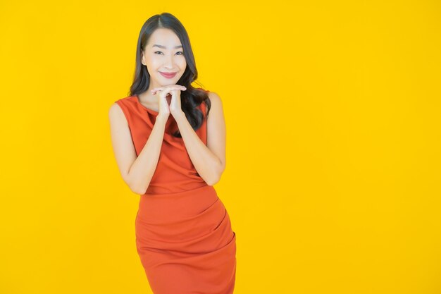 Portret mooie jonge Aziatische vrouw glimlach op geel
