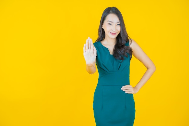 Portret mooie jonge Aziatische vrouw glimlach op geel