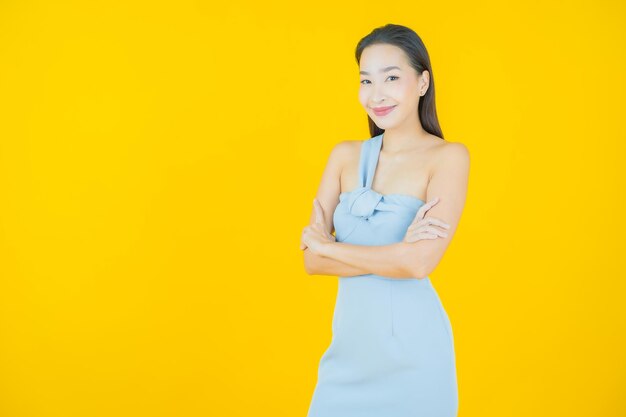 Portret mooie jonge Aziatische vrouw glimlach op geel