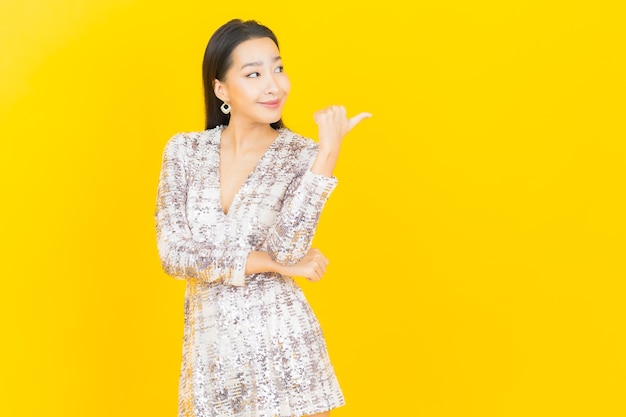 Portret mooie jonge Aziatische vrouw glimlach poseren op geel on