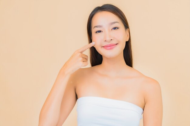 Portret mooie jonge Aziatische vrouw in spa met natuurlijke make-up op beige
