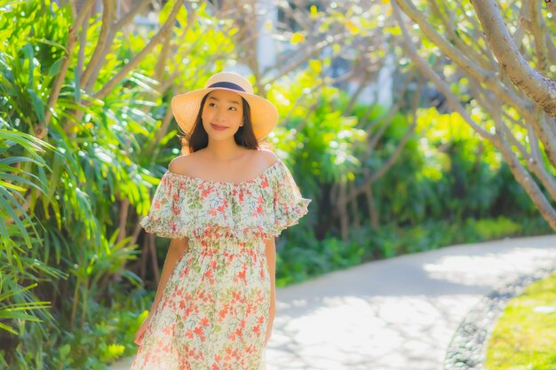Portret mooie jonge Aziatische vrouw lopen met gelukkig rond buiten tuinzicht