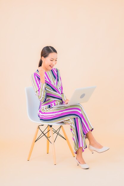 Portret mooie jonge Aziatische vrouw met computerlaptop op kleur