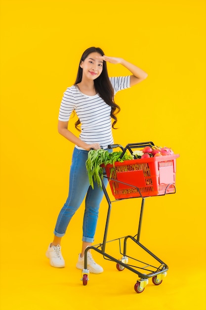 Portret mooie jonge Aziatische vrouw met de mand van de kruidenierswinkelmand van supermarkt in winkelcomplex