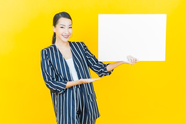 Portret mooie jonge Aziatische vrouw met lege witte billboard op kleur background