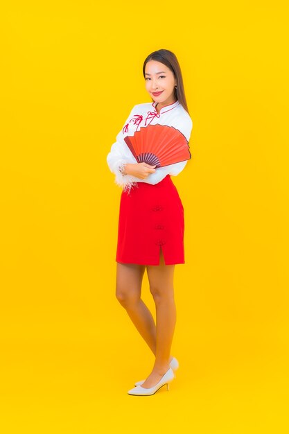 Portret mooie jonge aziatische vrouw met rode enveloppenbrief op geel