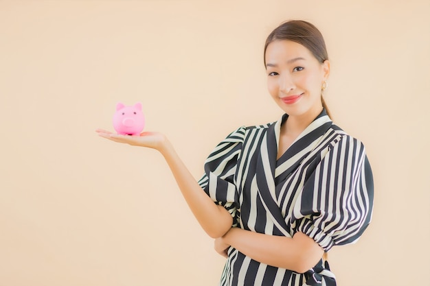 Portret mooie jonge Aziatische vrouw met roze spaarvarken
