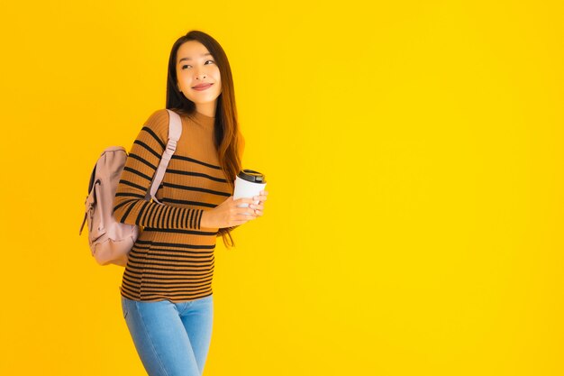 Portret mooie jonge Aziatische vrouw met rugzak en koffiekopje in haar hand