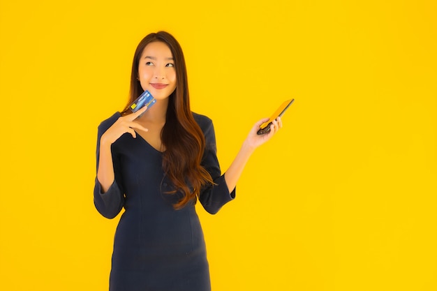 Portret mooie jonge Aziatische vrouw met telefoon en creditcard