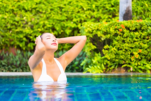 Portret mooie jonge aziatische vrouw ontspannen rond het zwembad in het resorthotel op vakantie