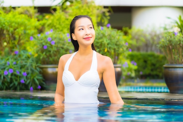 Portret mooie jonge aziatische vrouw ontspannen rond het zwembad in het resorthotel op vakantie
