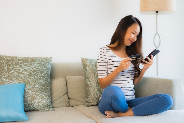 Portret mooie jonge Aziatische vrouwen met creditcard mobiele telefoon of computer om te winkelen