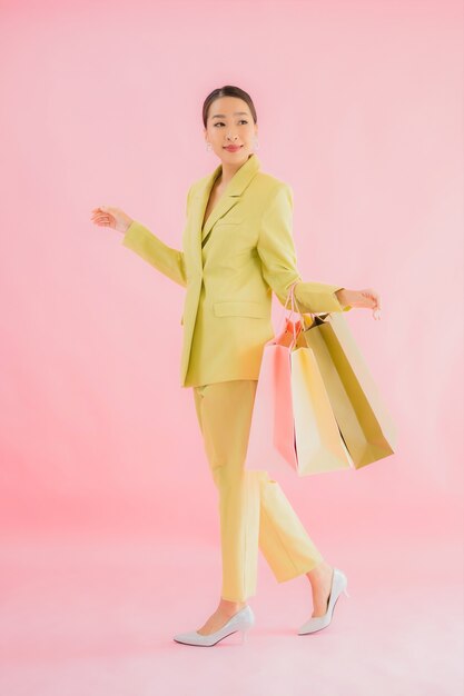 Portret mooie jonge Aziatische zakenvrouw met boodschappentas op kleur geïsoleerd