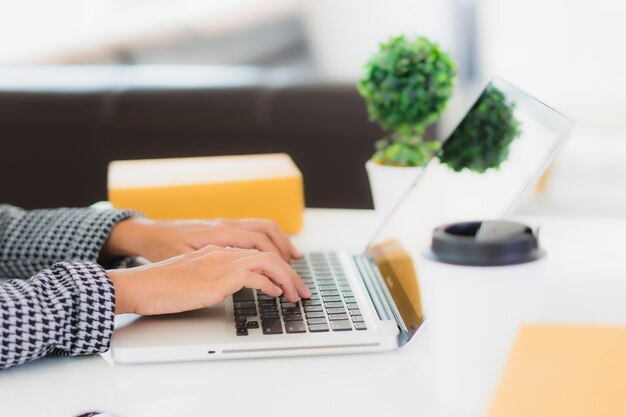 Portret mooie jonge Aziatische zakenvrouw werken vanuit huis met laptop mobiele telefoon met kartonnen doos klaar voor verzending