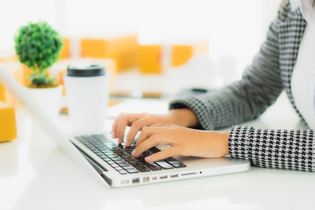 Portret mooie jonge aziatische zakenvrouw werken vanuit huis met laptop mobiele telefoon met kartonnen doos klaar voor verzending