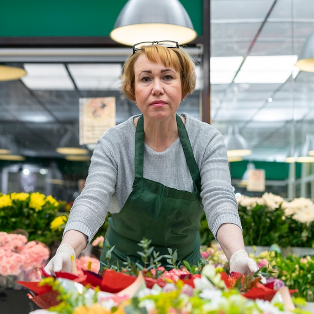 Portret senior vrouw poseren met bloemen