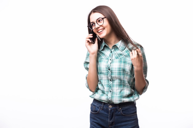 Portret van aantrekkelijke Spaanse vrouw op blauw t-shirt die op haar cel spreekt terwijl status en op studio glimlacht