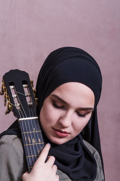 Gratis foto portret van arabische vrouw met gitaar