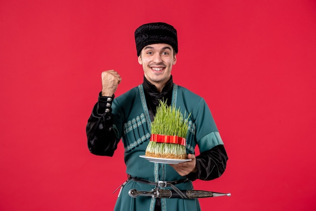 Gratis foto portret van azeri man in klederdracht met semeni op rood