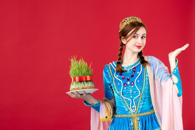 Portret van azeri vrouw in traditionele kleding met semeni op rood