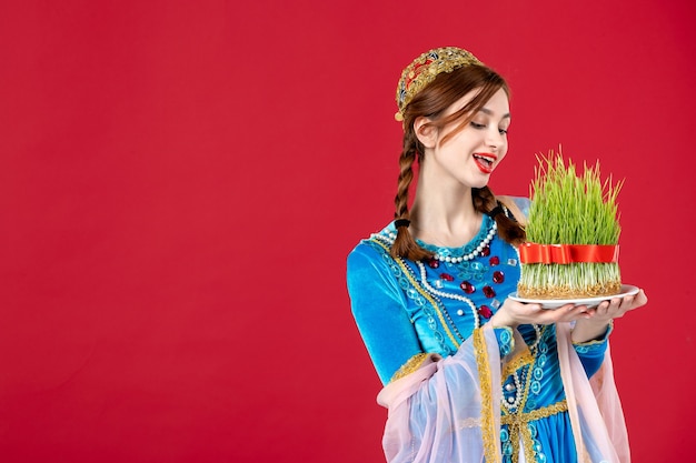 Portret van azeri vrouw in traditionele kleding met semeni op rood